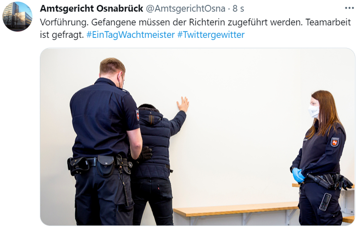 alt="Der / Die Wachtmeister*in führt einen Gefangenen vor."